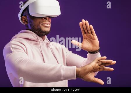 African professional boxer looking through the competition with his participation, using VR glasses, studying mistakes and tactic of opponent Stock Photo