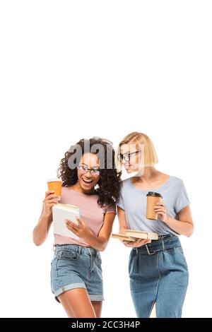 Multiethnic students looking at smartphone while holding coffee to go isolated on white Stock Photo