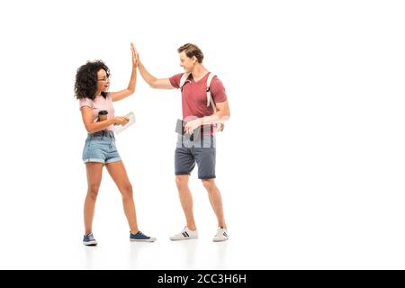 Student with backpack giving high five to african american friend on white background Stock Photo