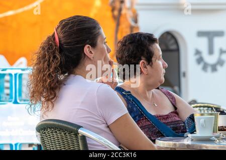 Huelva, Spain - August 17, 2020: woman is smoking a cigarette in a bar terrace Stock Photo
