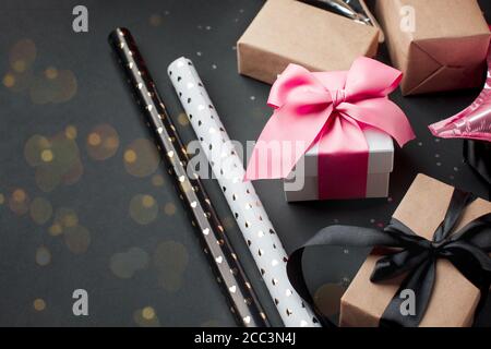 Gift present boxes wrapped with luxury pink bow on dark background. Horizontal with copy space, seasonal sale, winter holiday, Xmas, New Year, black f Stock Photo
