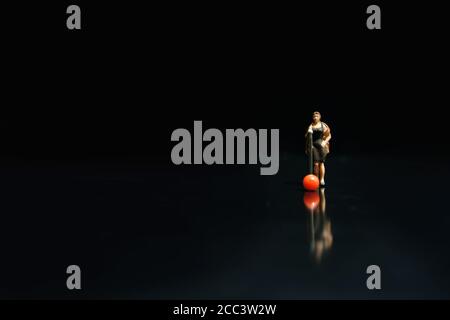 Miniature photography - elegant women singer singing on shiny black stage with reflection Stock Photo