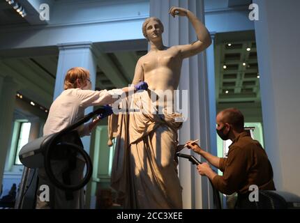 Sovati Smith (left) and Alex Truscott from the collections team dusting the Townley Venus Roman sculpture (1st or 2nd century AD), in the Greek and Roman Sculpture Gallery at the British Museum, London, as they prepare to re-open to the public on August 27 following the coronavirus lockdown. Ahead of reopening, the British Museum has embarked on the biggest single programme of cleaning in decades. Stock Photo