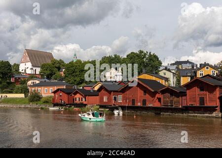 River Porvoonjoki with Old Town wooden storage buildings on riverbank and medieval stone and brick cathedral in the background in Porvoo, Finland Stock Photo
