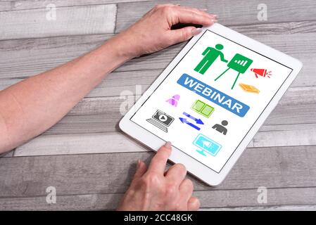 Webinar concept shown on a tablet used by a woman Stock Photo
