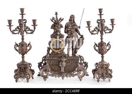 Studio photo of bronze antique mantel clock and two candlesticks on white background. Western Europe. 19th century Stock Photo