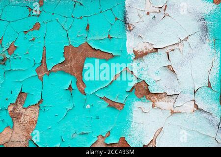 Peeling turquoise paint on a concrete wall. Blue and white painted abstract backgrounds, cracked rusty metal surface, faded texture, grunge wallpaper Stock Photo