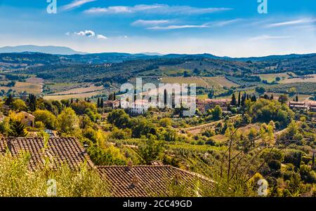 Beautiful panoramic view of the lovely countryside of the famous medieval hill town San Gimignano, a typical Tuscan landscape with its valleys on a... Stock Photo