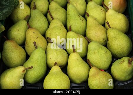 Green pears are stacked in a box for sale Stock Photo