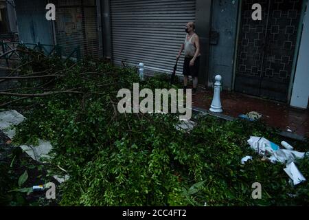 (200819) -- MACAO, Aug. 19, 2020 (Xinhua) -- A man walks past fallen trees in Macao, south China, Aug. 19, 2020. China's Macao Special Administrative Region has downgraded its typhoon signal from highest No.10 level to No.8 on Wednesday at 7:30 a.m. local time, but the low-lying areas near the coastline were flooded, as Typhoon Higos had made landfall in the neighboring city of Zhuhai in the morning. Credit: Xinhua/Alamy Live News Stock Photo