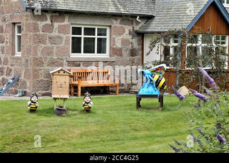 Quaint Scottish cottage garden with ceramic bee and bee gnomes Stock Photo