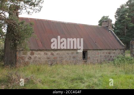 Stone built farm house with rusty tin roof and copy space Stock Photo