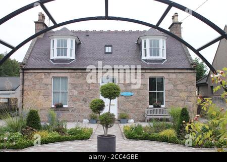 Station cottage looking through a garden arch Stock Photo