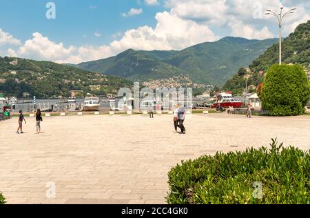 Como, Lombardy, Italy - June 18, 2019: Tourists enjoying Como Lake promenade in a hot summer day in the center of Como, Italy Stock Photo