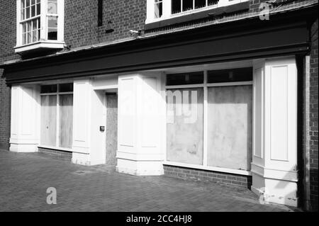Bankrupt closed down retail shop business with whitewashed windows in a pedestrian shopping centre mall black & white monochrome image stock photo Stock Photo