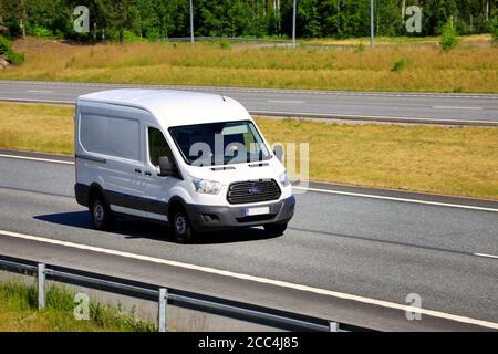 White Ford transit van delivers goods along multiple lane freeway. Salo, Finland. June 18, 2020. Stock Photo