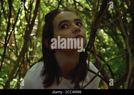 Young Woman Among Branches in the Forest Stock Photo