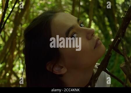 Young Woman Among Branches in the Forest Stock Photo