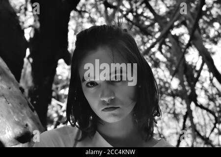 Young Woman Among Branches in the Forest Stock Photo