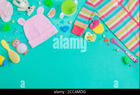 Baby accessories baby jumpsuit, socks, soother and toys background with copy space Stock Photo