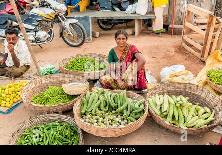 Puttaparthi, Andhra Pradesh, India - January 13, 2013: Indian women sell vegetables at street market of Puttaparthi. Stock Photo