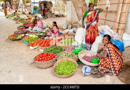 Puttaparthi, Andhra Pradesh, India - January 13, 2013: Indian women sell vegetables at street market of Puttaparthi. Stock Photo