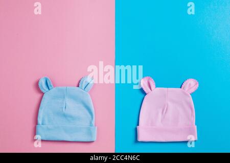 Babys caps with ears over pink and blue background with copy space Stock Photo