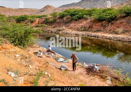Puttaparthi, Andhra Pradesh, India - January 11, 2013: A Man washing clothes on the banks of the river at the village of Puttaparthi, India Stock Photo