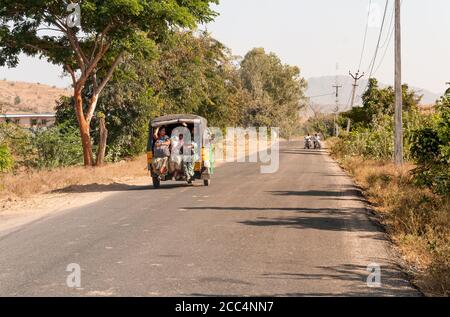 Puttaparthi, Andhra Pradesh, India - January 12, 2013: Indian women travel in rickshaw taxi along the road of Puttaparthi village, India Stock Photo