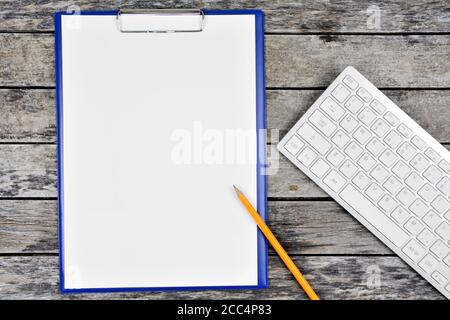 Clipboard with blank white paper with pen and keyboard computer on desk Stock Photo