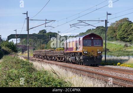 DB Cargo rail UK class 66 locomotive 66147 on the west coast mainline with a freight train carrying concrete railway sleepers Stock Photo