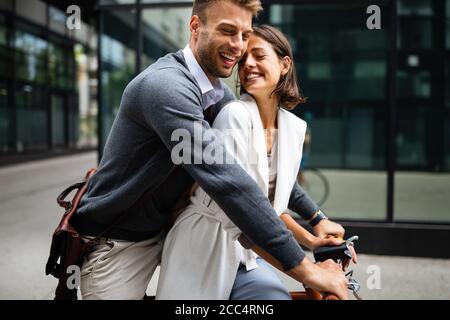 Portrait of happy young couple riding a bike and having fun together outdoor Stock Photo
