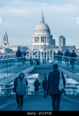 People wandering over Millennium bridge in London at rush hour.  St Paul's Cathedral is in the background. Stock Photo