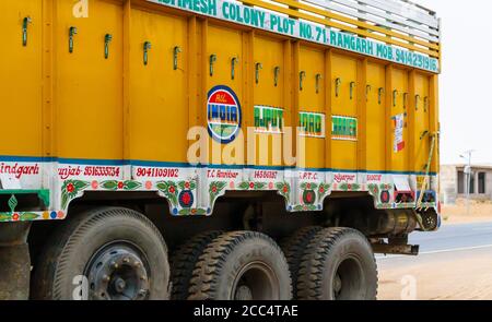 Driving in India: view of a typical brightly coloured side of an Indian lorry parked by the roadside, Dausa, Rajasthan, north India Stock Photo