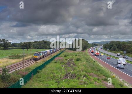 Direct Rail Services class 88 bi mode Electric locomotive 88004 hauling a container freight train on the west coast mainline by the M6 motorway Stock Photo