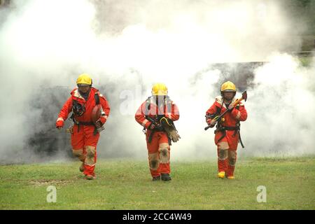 The fireman is preparing to put out the fire at the fire engine. Because the fire was burning in the building. Stock Photo