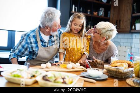 Smiling grandparents having breakfast with their granddaughter Stock Photo