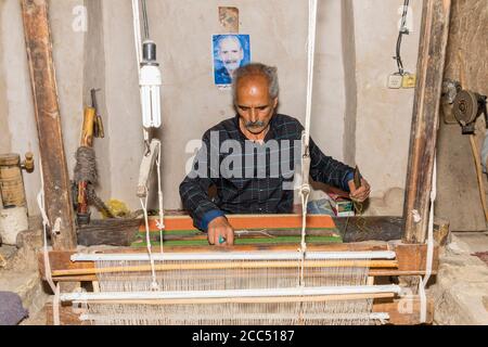 Iranian man working on a loom, Na’in, Isfahan Province, Iran, Asia Stock Photo