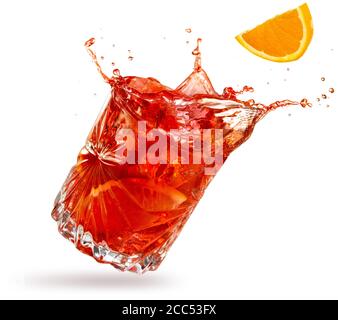 orange slice falling into a splashing negroni tilted on white background Stock Photo