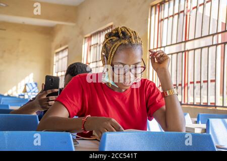 Shallow focus of two young African students wearing facemasks and studying in a classroom Stock Photo