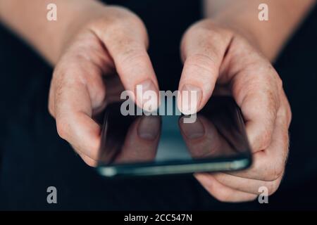 Female hands using modern mobile phone to type text message, selective focus Stock Photo
