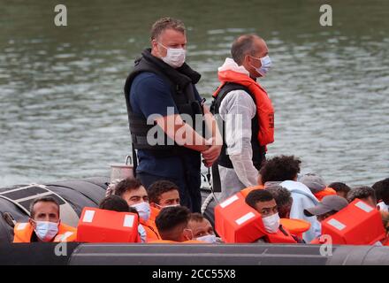 A group of people thought to be migrants are brought into Dover, Kent, following a number of small boat incidents in the Channel earlier today. Stock Photo