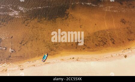 Aerial view on coastline. Summer seascape with clear water in sunny day. Top view of boat from drone.  Stock Photo