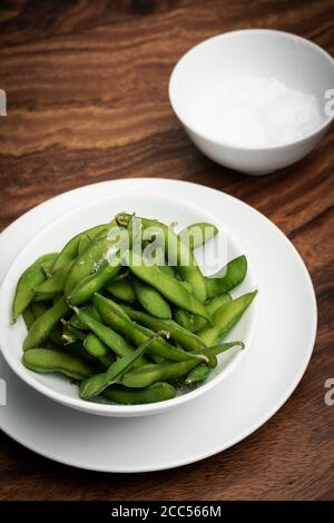 organic edamame beans snack in bowl on table with sea salt Stock Photo
