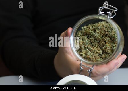 Glass jar full of cannabis buds ready to smoke. Marijuana smoking industry business Stock Photo