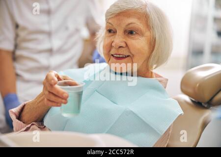 Smiling good looking female holding cup with water Stock Photo