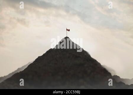 flag planted on top of a mountain, success concept Stock Photo