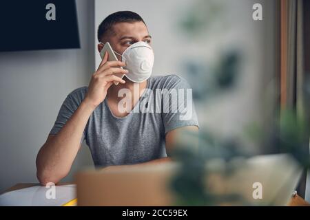 Handsome young man in medical mask staying at home
