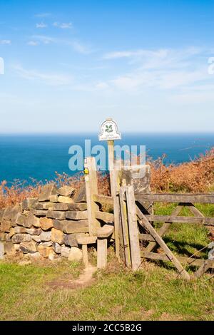 Stile on The Cleveland Way coastal path above Loftus Alum quarries (name on sign) between Staithes and Skinningrove, North Yorkshire, England. UK Stock Photo