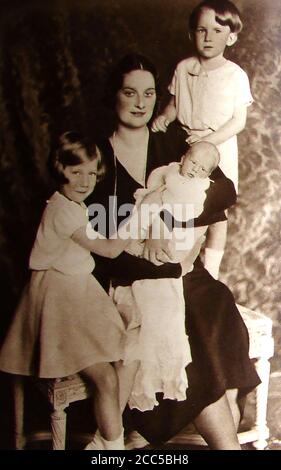 1934 - A portrait of Queen Astrid of Belgium (formerly Astrid of Sweden) , 1905-1935 , who was killed in a motoring accident on August 29th 1935, pictured with her children ( Joséphine-Charlotte, Albert and Baudouin (standing).  Her husband,   King Leopold was driving the car when the vehicle hit a parapet and entered a lake. Their chauffeur was sitting in he back of the Packard One-Twenty convertible and was thrown into a tree resulting in her death from the impact .The Belgian postal authorities issued a postage stamp showing her portrait outlined in black, known as the Astrid Mourning issue Stock Photo